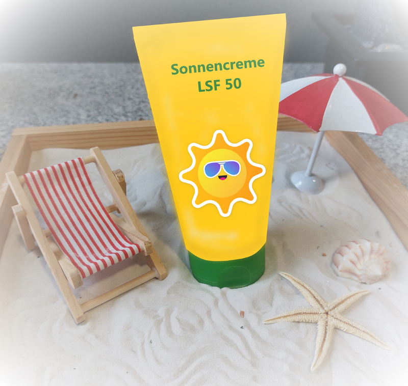 Das Bild zeigt eine Tube Sonnencreme, eine Sonnenbrille, einen Seestern und einen Mini-Liegestuhl im Sand.